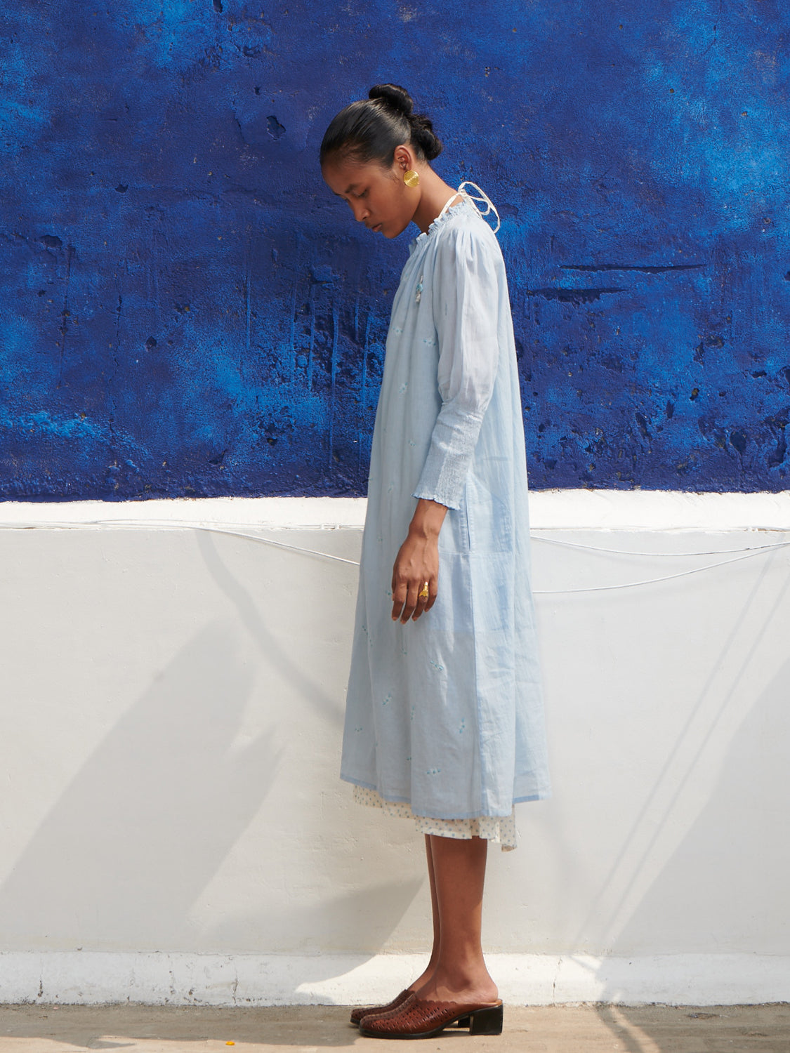 Light blue, smocked neck, geranium dress in mulmul cotton with hand embroidered detail, paired with a halter neck chemise.