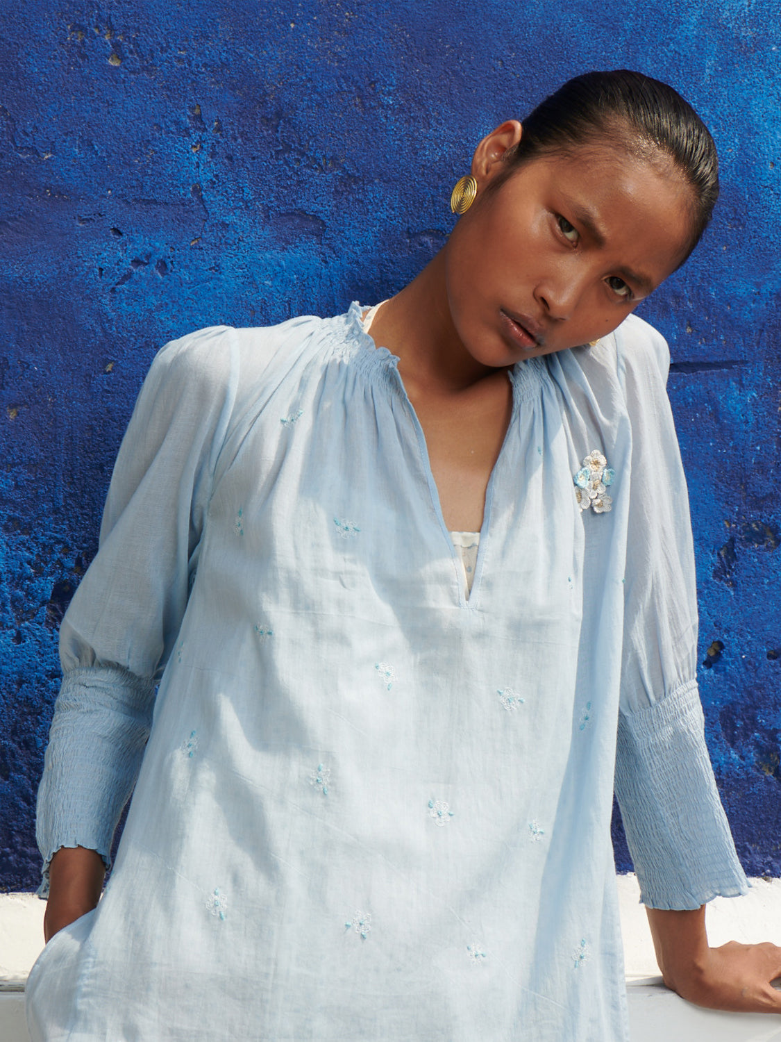 Light blue, smocked neck, geranium dress in mulmul cotton with hand embroidered detail, paired with a halter neck chemise.
