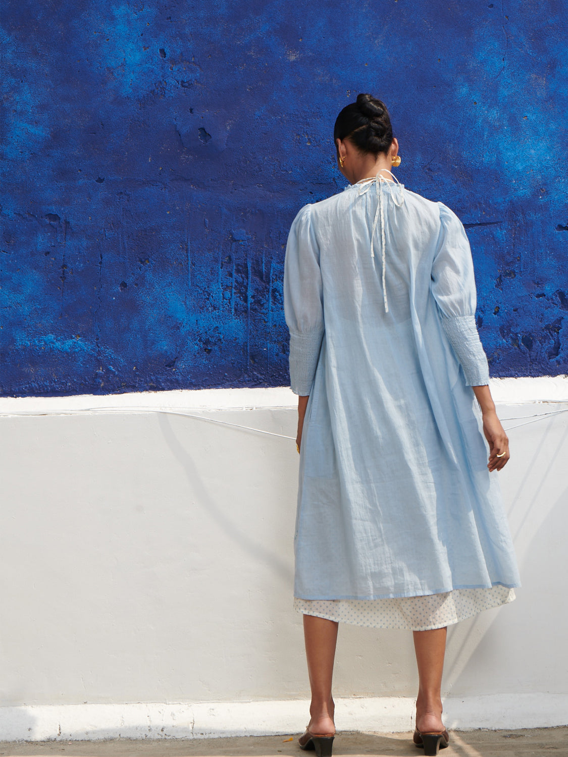 Light blue, smocked neck, geranium dress in mulmul cotton with hand embroidered detail, paired with a halter neck chemise.